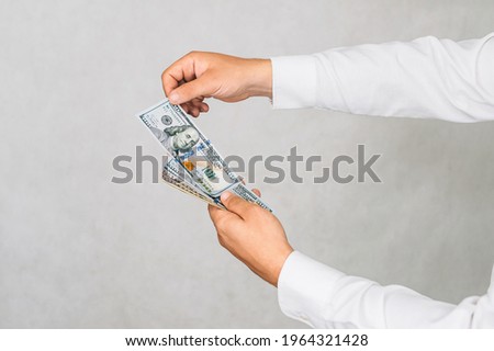 The money is in the hands of a man. On a light background