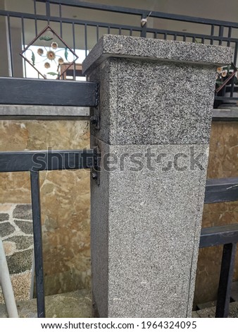 pillars for iron fence made of black natural stone as a finishing material.