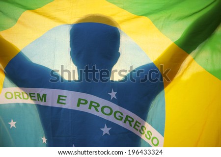 Shadow silhouette of man holding Brazilian flag backlit by bright sun Royalty-Free Stock Photo #196433324