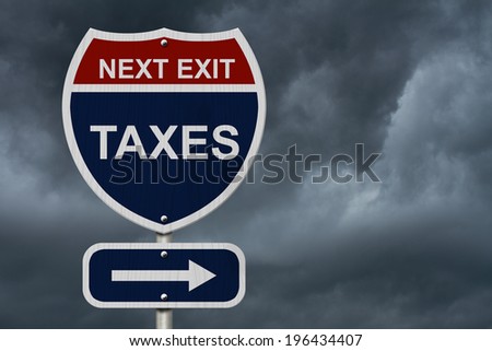 Taxes this way, Blue and Red Interstate Sign with word Taxes and an arrow with stormy sky background