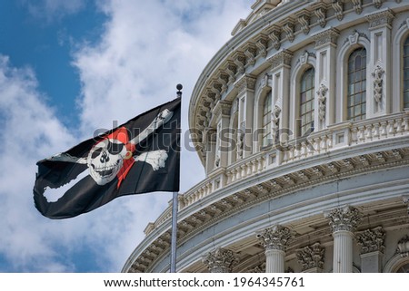 Jolly Roger Pirate flag waving on Washington DC Capitol detail on cloudy sky