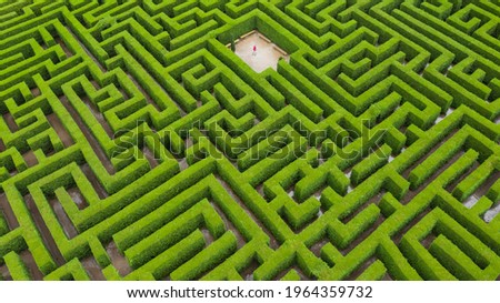 person in a maze surrounded by green nature Royalty-Free Stock Photo #1964359732