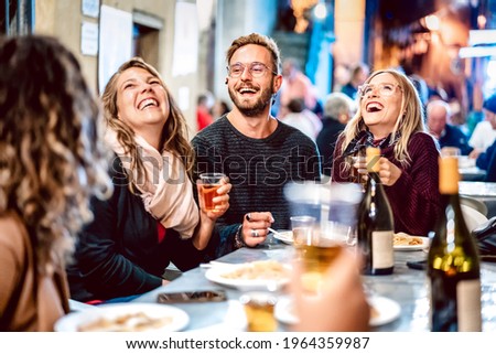Happy friends having fun drinking white wine at street food festival - Young people eating local plate at restaurant reopening together - Travel and dinning life style concept on light neon filter Royalty-Free Stock Photo #1964359987