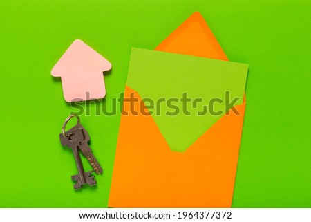 Keys on a chain with an empty opened envelope with free space for text as a symbol of winning a property.