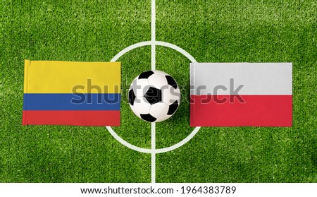 Top view ball with Colombia vs. Poland flags match on green football field.