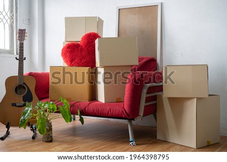 Moving day concept, cardboard carton boxes stack with household belongings in modern house living room, packed containers on floor in new home, relocation, renovation, removals and delivery service Royalty-Free Stock Photo #1964398795