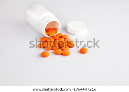 A handful of tablets vitamin C tablets on white background. Healthy lifestyle concept. Copy space. Close-up.