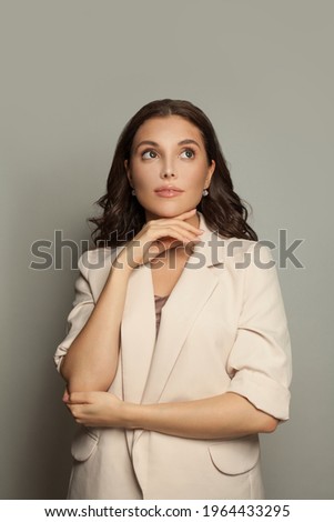 Cute woman in suit on gray background
