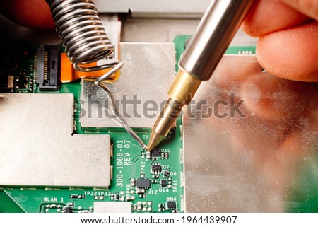 To avoid programmed obsolescence of electronic devices, these can be repaired by soldering. Royalty-Free Stock Photo #1964439907