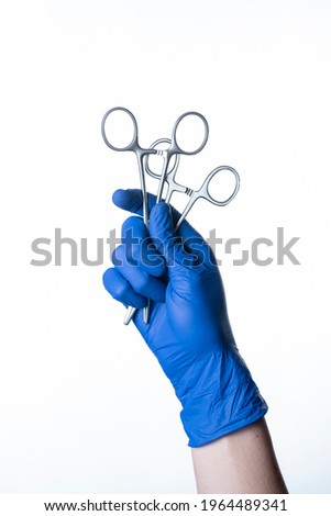 doctor wearing gloves holding surgical scissors