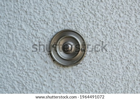 Stainless steel doorbell on a white wall