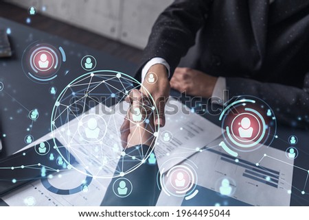 Recruitment concept to hiring of a new talented specialists for international company. Handshake to sign in of employment agreement. Social media hologram icons. Women in business concept. Royalty-Free Stock Photo #1964495044