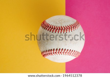 Pink and yellow background with used baseball and copy space for sport.
