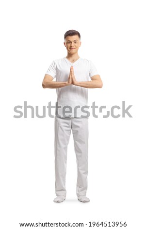 Young man in white clothes standing and practicing yoga  isolated on white background