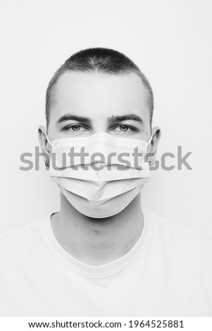 Black and white portrait of a guy in a mask.  The concept of a global coronavirus pandemic.