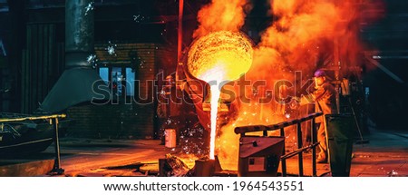 Liquid iron molten metal pouring in container, industrial metallurgical factory, foundry cast, heavy industry background Royalty-Free Stock Photo #1964543551