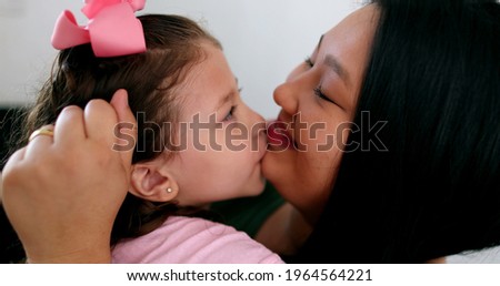 Cute little girl hugging and loving mom. Candid authentic affection and love between mother and child