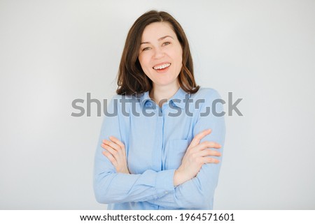 Young woman in blue shirt smiles and is very happy. Nice student on white background. Happy business woman or teacher 