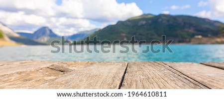 Panoramic view from wooden pier to mountains and azure lake. Beautiful summer landscape with selective focus. Taurus Canyon, Turkey.