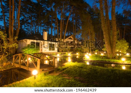 Cozy resort by the lake in the conifer forest at night Royalty-Free Stock Photo #196462439