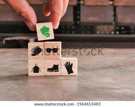 Safety at work concept. Hand putting wooden block with safety icons. Royalty-Free Stock Photo #1964653483