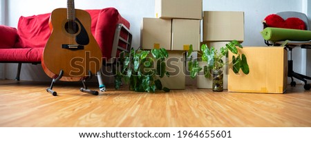 Horizontal photo heap of cardboard boxes with personal belongings in living room at moving relocation day no people, delivery service concept, banner for website header design with copy space for text