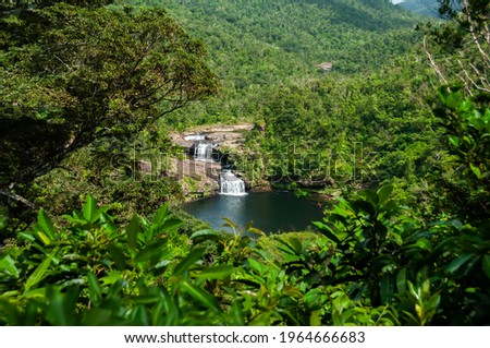 Amazing waterfall with two falls in the middle of  Iriomote island forest. Refreshing swimming hole, tropical vegetation around. Natural world heritage.  Royalty-Free Stock Photo #1964666683