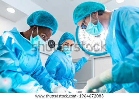 Group of medical team urgently doing surgical operation and helping patient in theater at hospital. Doctor and assistant nurse operating for help patient from dangerous emergency case .