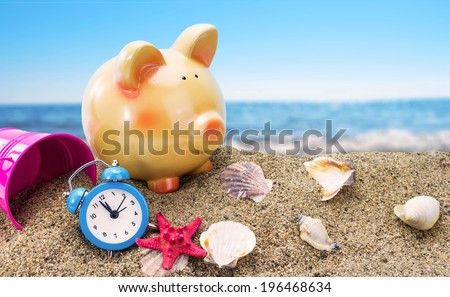 Piggy bank on sand with summer sea background 