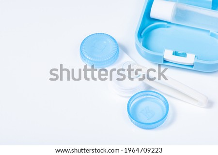 Soft contact lenses with solution close-up, container and tweezers on white background with place for text. Macro photography