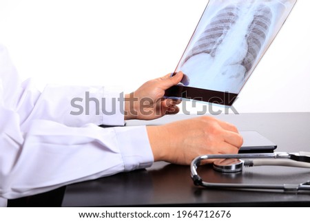 Medical doctor looking at x-ray picture of lungs in hospital. Covid-19 consept, Woman Doctor Looking at X-Ray Radiography in patient's Room