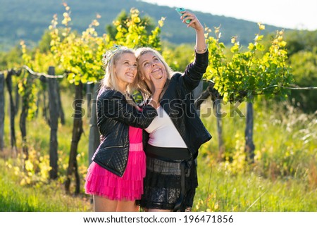 two young women and twins taking selfie with mobile phone