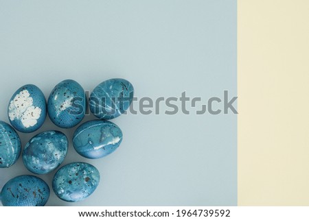 Creative easter eggs in the color of the blue starry sky on a light blue background with copy space, top view, flat lay. Easter concept, easter background
