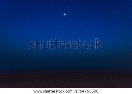 Jupiter in night sky, evening dusk over sea coast