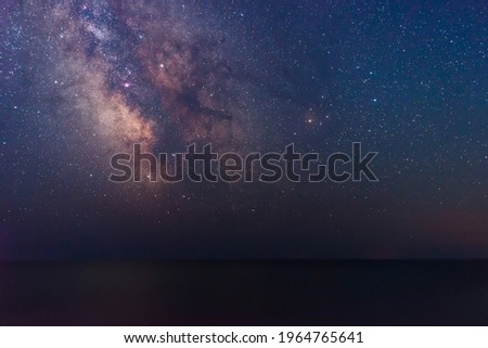 Milky way galaxy with dark nebulae rise above sea surface, night sky with stars, space background