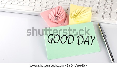 text GOOD DAY on colorful envelopes on keyboard on white background