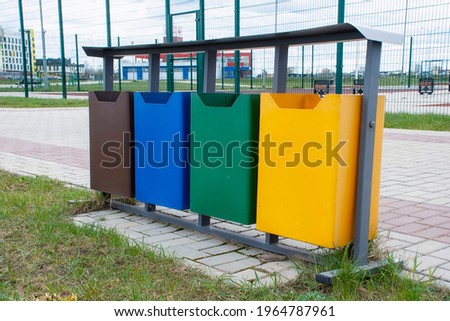 Ecological trash cans in different colors in the open air park. Distribution of household waste