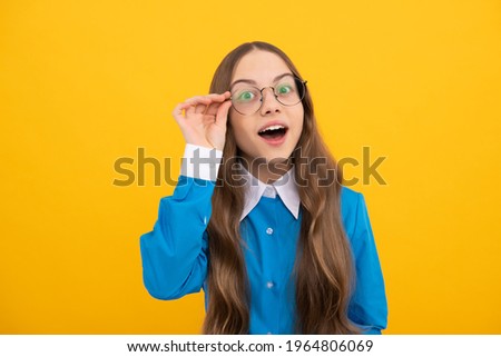 Curious school age girl child look through eyeglasses yellow background, curiosity.