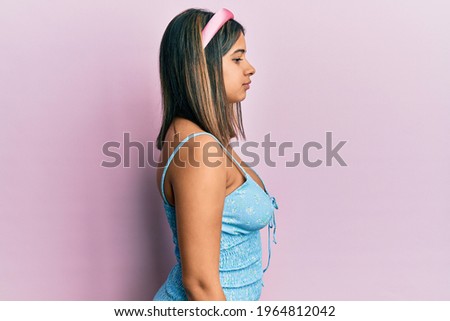 Young latin woman wearing summer clothes looking to side, relax profile pose with natural face with confident smile. 