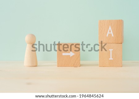 Human and AI; Wooden blocks with "AI" text of concept and human toys. Royalty-Free Stock Photo #1964845624