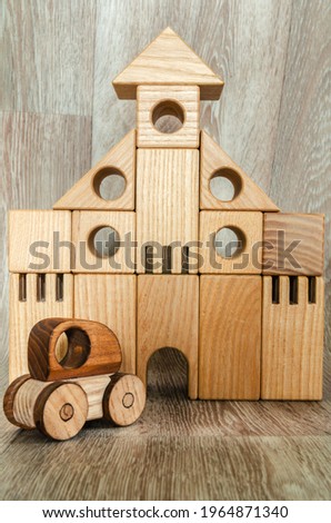 Conceptual photography, wooden figures of a house and a car.