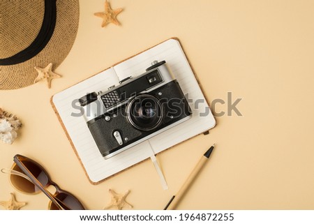 Top view photo of hat sunglasses pen camera on planner seashell and starfishes on isolated beige background with copyspace