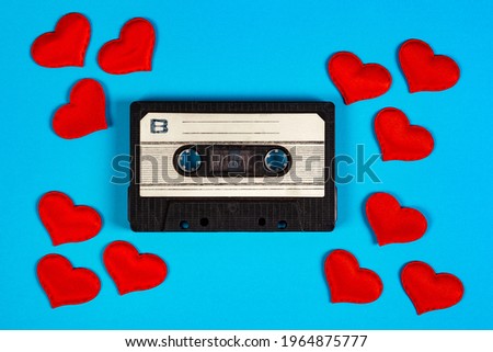 Old Audio Cassettes with a Red Hearts on the Blue Paper Background closeup