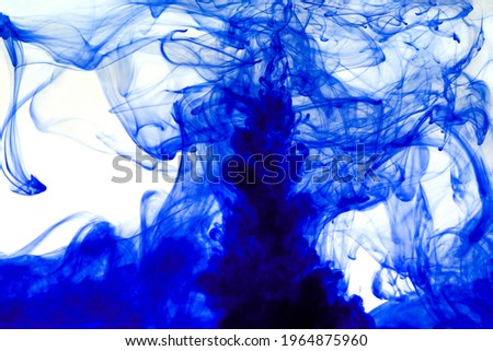 Blue ink dissolving in water creating abstract shapes