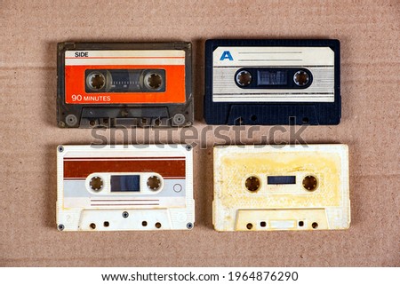 Four Old Audio Cassettes on the Cardboard Background closeup