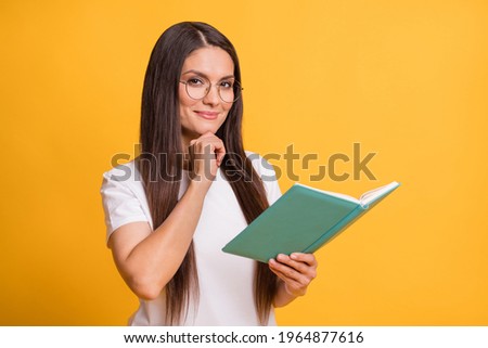 Photo of minded serious mature woman hold book hand chin wear glasses isolated on yellow color background