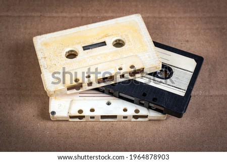 Three Old Audio Cassettes on the Cardboard Background closeup