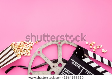 Film reel with popcorn and clapperboard. Cinema concept