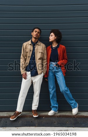 full length of young african american man posing with stylish woman standing with hand in pocket Royalty-Free Stock Photo #1965034198