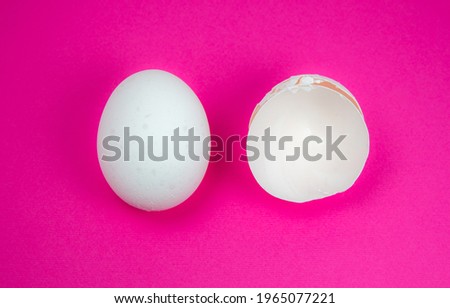 White egg and  eggshell on the pink background. Copy space. Minimalism, original and creative photo. Beautiful wallpaper. Easter holidays.